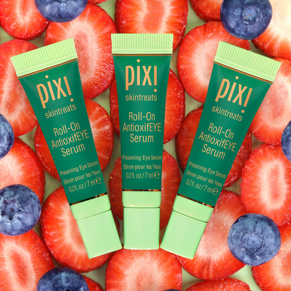 Three Pixi Roll-On Antioxidant Eye Serum bottles on strawberries and blueberries view 1