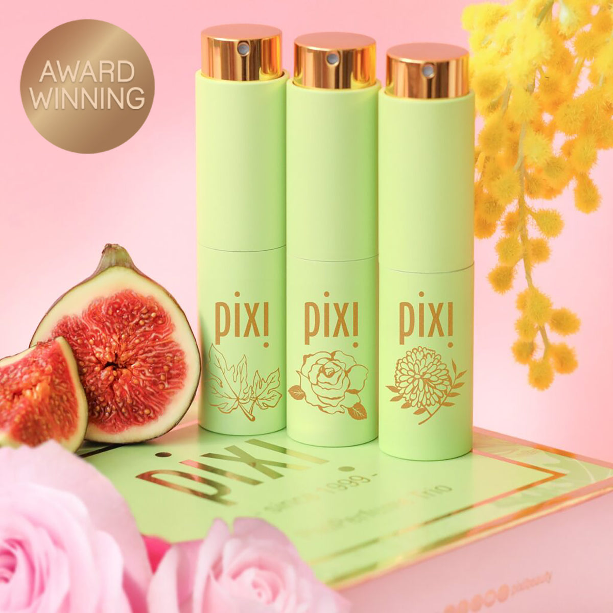 Award Winning: PixiPerfume Gift Trio shown on a pink background with plants -