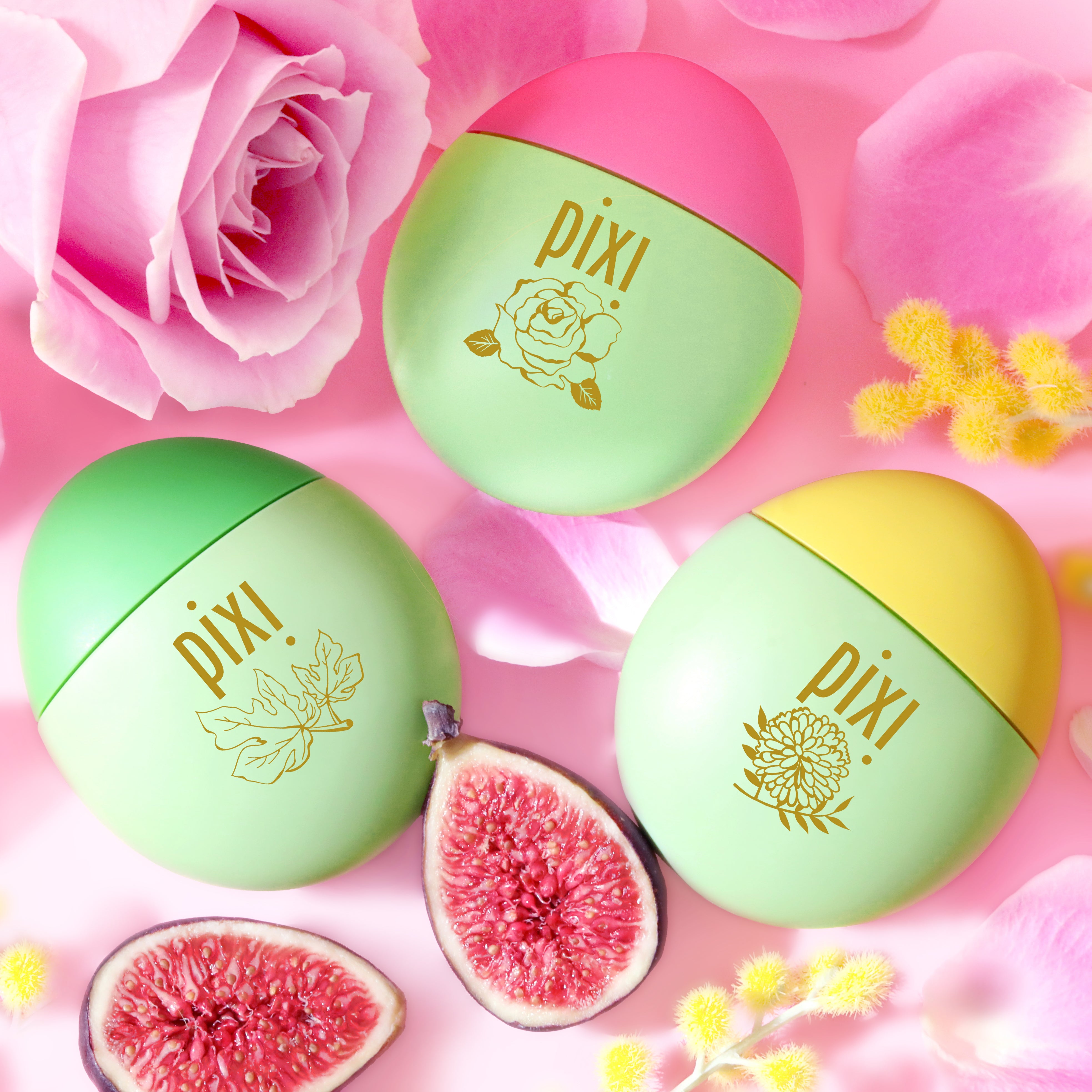 HandHero Hand Lotion fragrance trio featuring PixiRose, PixiMimosa and PixiFig scents shown on a pink background with roses, mimosa blooms and figs.  The containers have gold foil illustrations and the Pixi brand name.