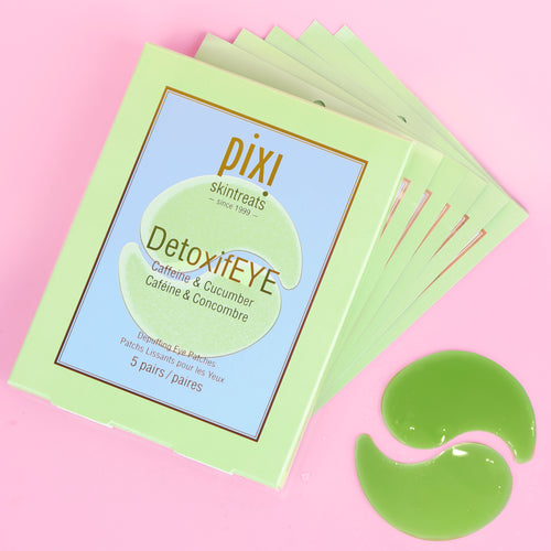 A 5-pack stack of Pixi Skintreats DetoxiEYE eye gel patches in a light green box, displayed on a pink background with two green gel patches placed in front. view 1