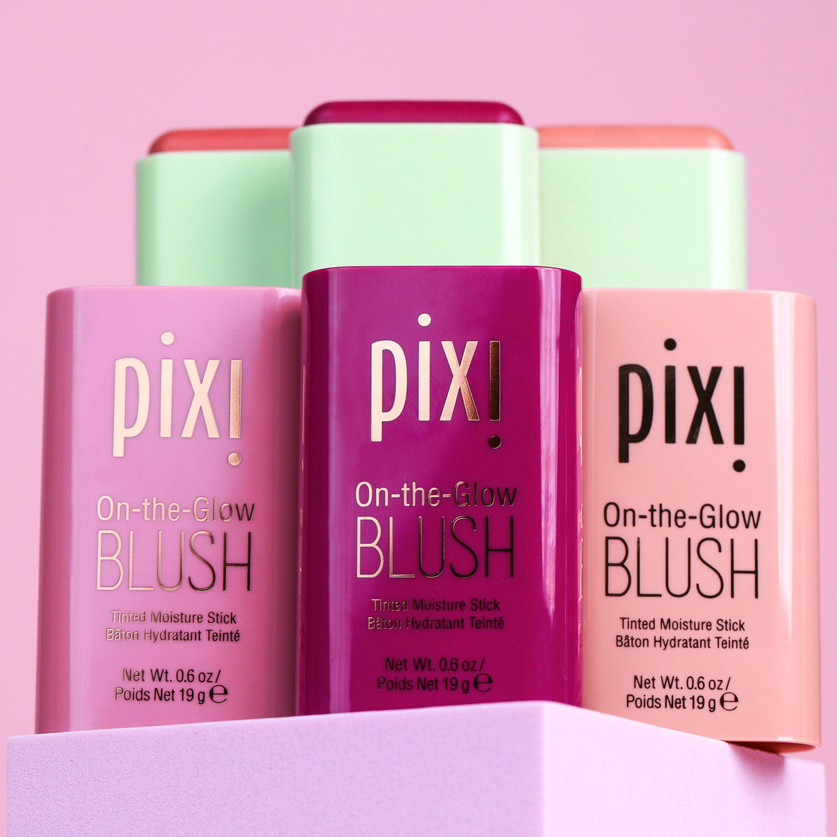 3 shades of On-the-Glow Blush shown with open lids on a pink background
